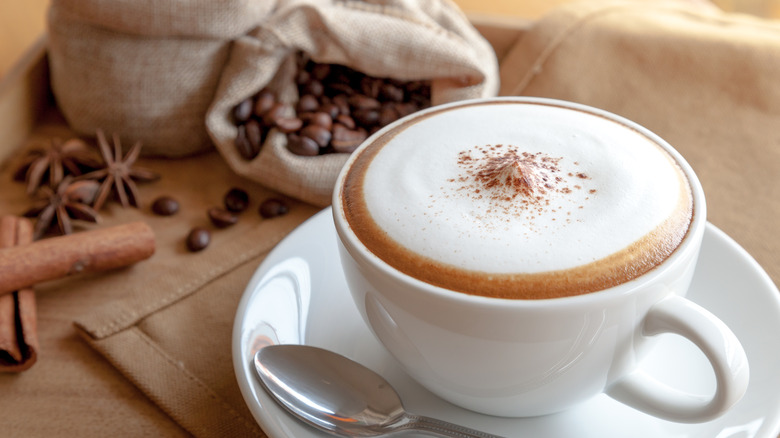 Frothed cappuccino cinnamon sticks coffee beans