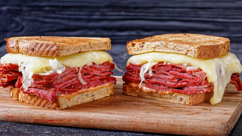 toasted reuben sandwich cut in half on a board
