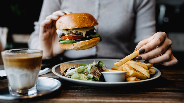 Woman eating burger and fries