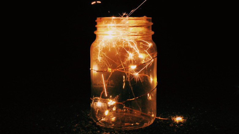 fairy lights in a mason jar against a black background.