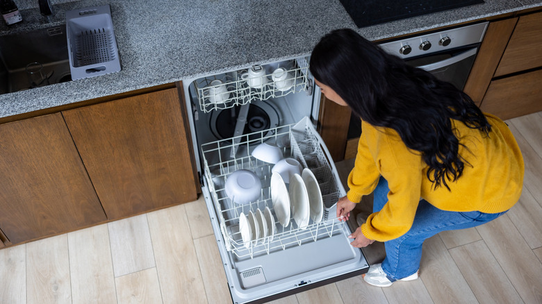 Top down view of a person loading a dishwasher