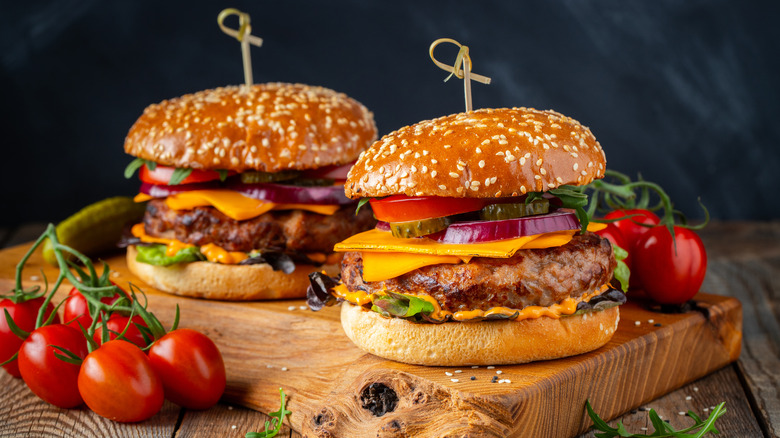 dressed burgers on wooden board