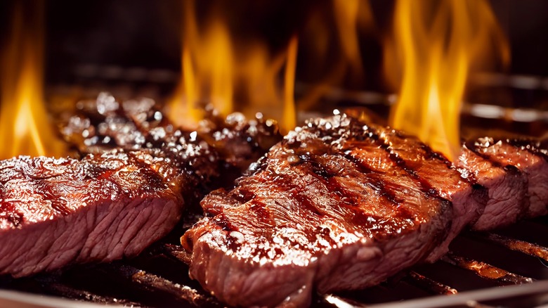 steaks on a flaming grill