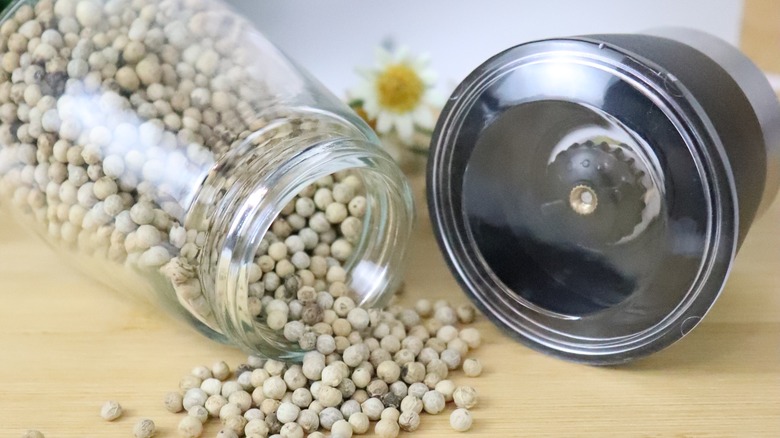 Open pepper grinder with peppercorns
