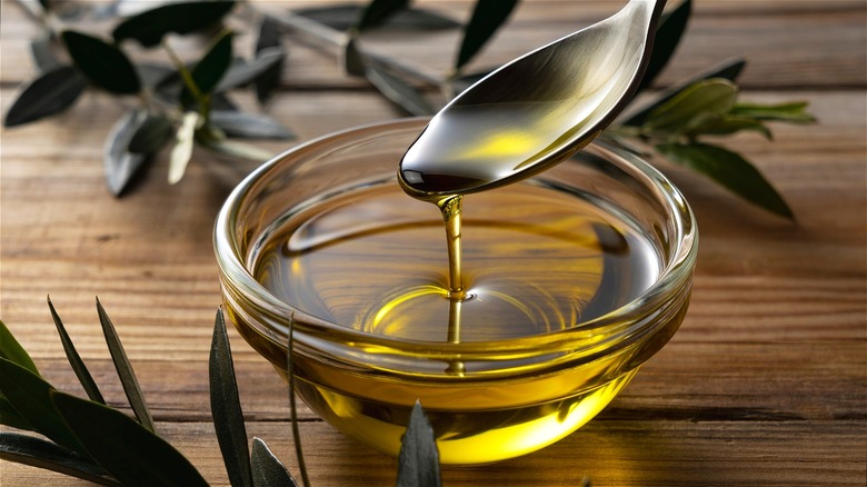 Clear cup of olive oil with spoon