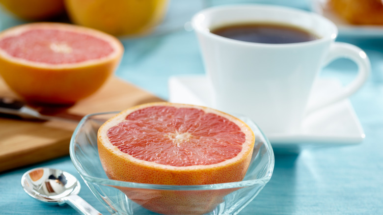 A grapefruit half and mug of coffee at breakfast