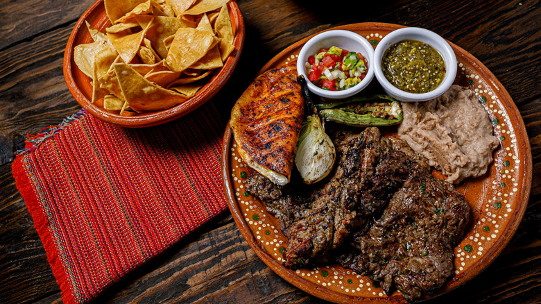 Carne asada platter with refried beans, pico de gallo, and tortilla chips