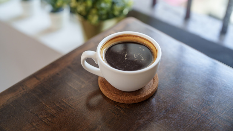 Black cup of coffee on a table corner