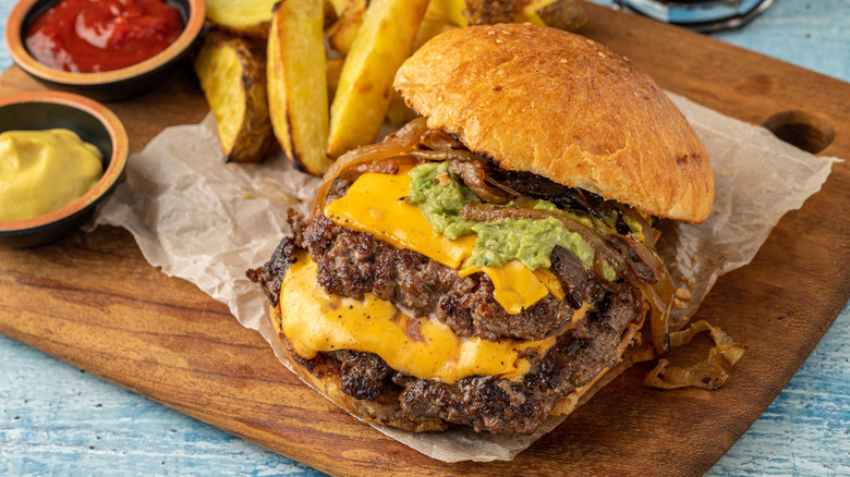 A smash burger with chunky fries, mustard, and ketchup