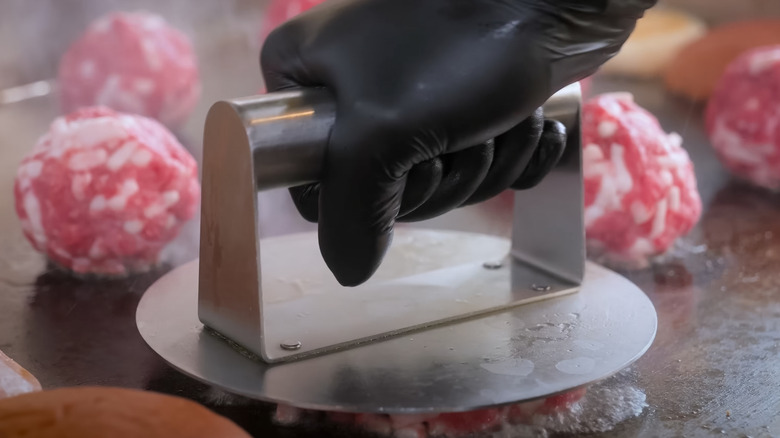 Flattening smash burgers with a burger press