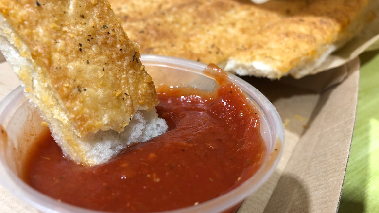 Dipping breadstick in marinara