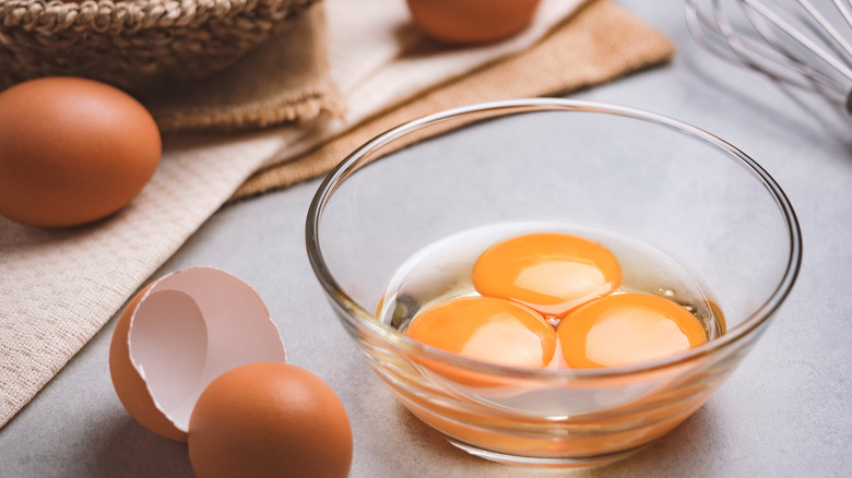 Raw eggs in glass bowl