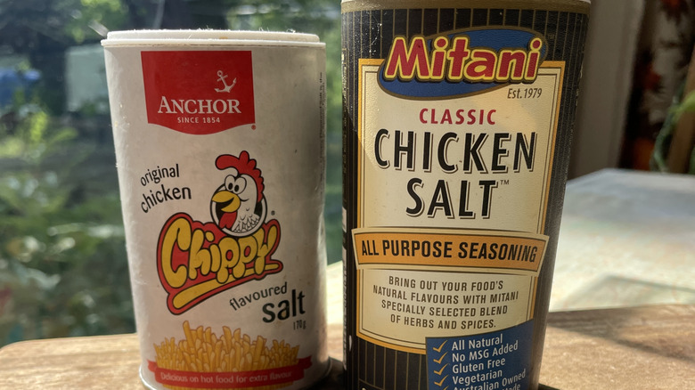 Rotisserie chickens roasting on a spit over coal