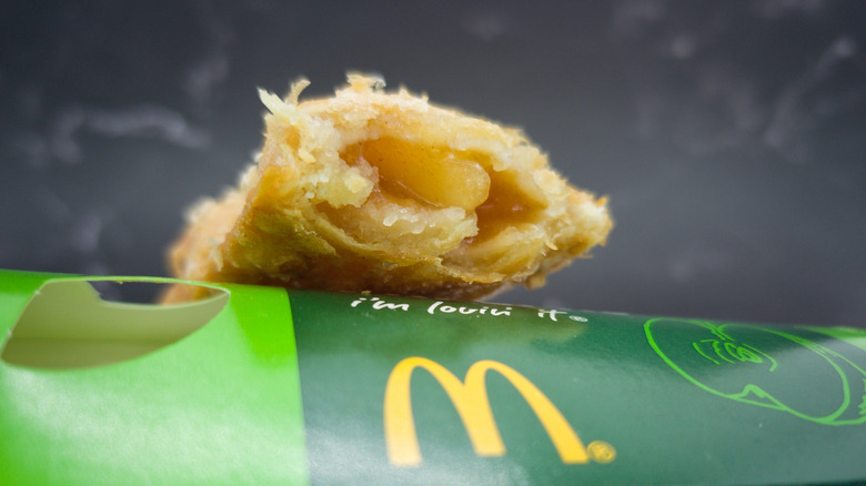 McDonalds apple pie with bite removed on top of green box