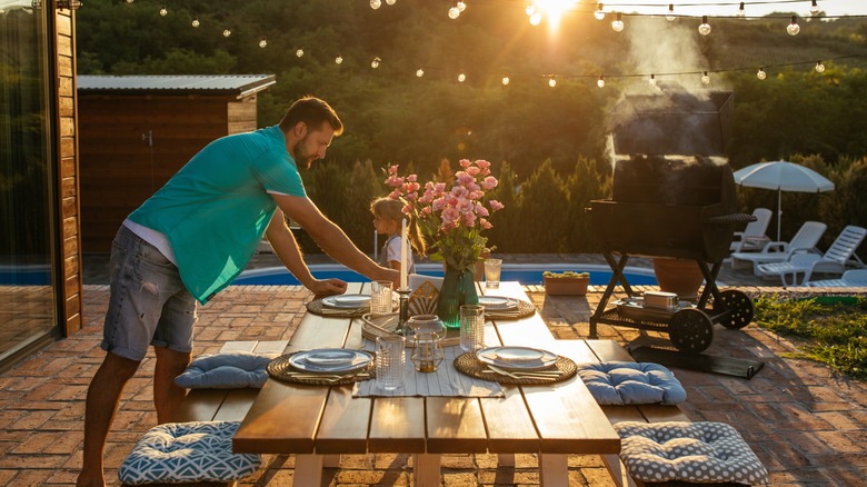 man setting outdoor dining table