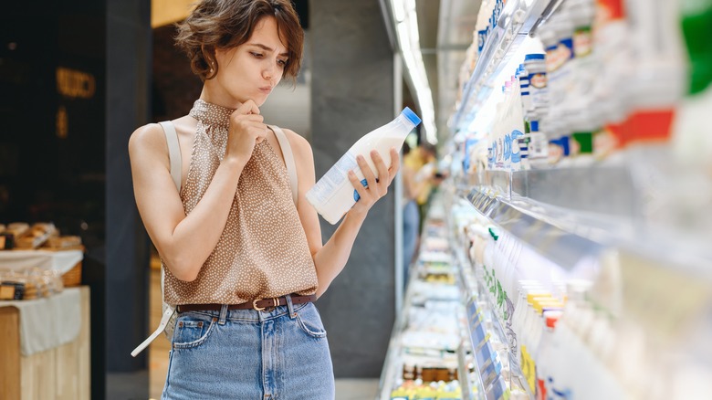 woman buying milk in a grocery store