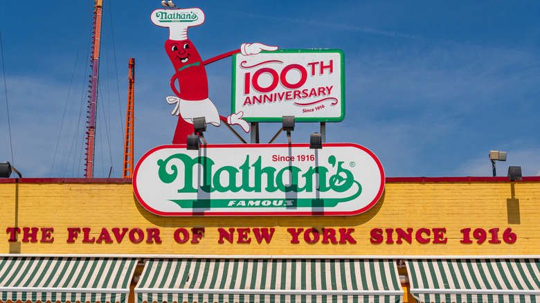 Close up of Nathan's Famous hot dog with fries and drink