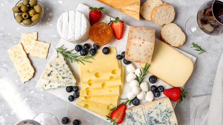 Cheeseboard with various cheeses and sliced baguette.