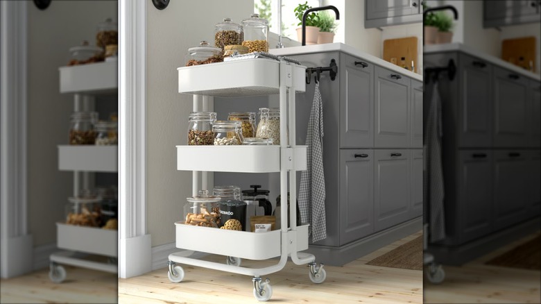 White Råskog utility cart used for mobile snack storage at the end of a kitchen cabinet