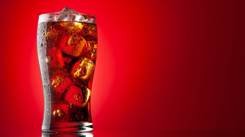 Glass of soda on red background