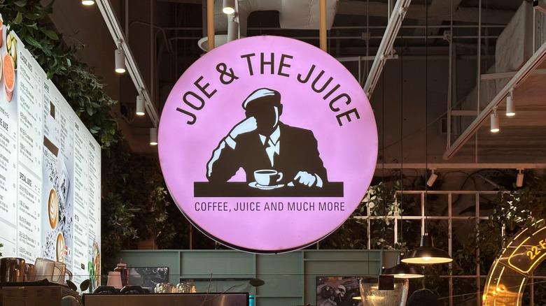 A sign of the pink and black Joe & The Juice logo inside one of the coffee shop's locations
