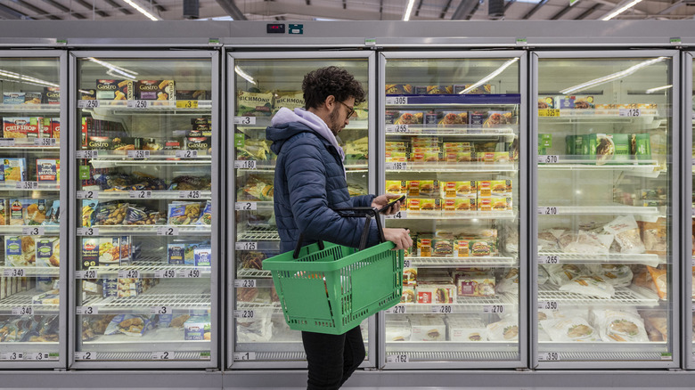 Man grocery shopping with empty basket