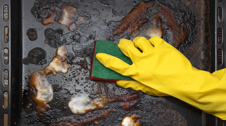 scrubbing dirty baking sheet