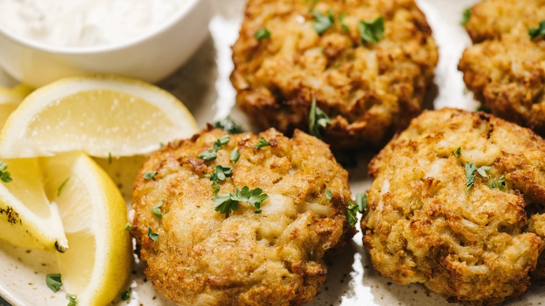 crab cakes on a plate with lemon