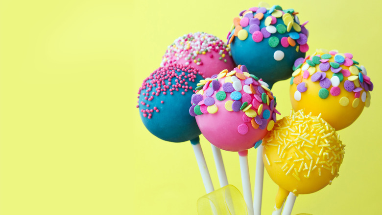 Brightly colored cake pops with yellow background