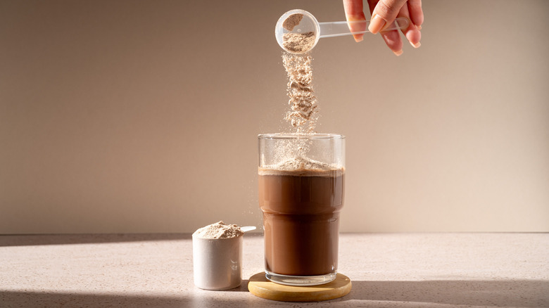 chocolate protein powder getting poured into a shake