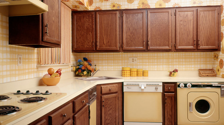 A 1970s kitchen with dark wood cabinets