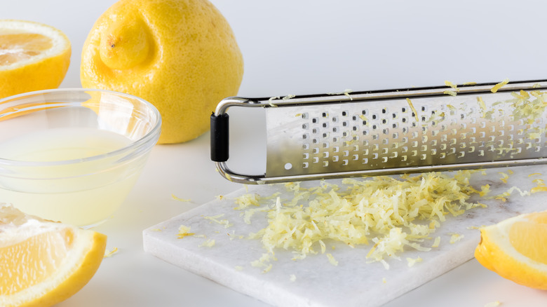 Microplane zester, lemon, and zest on a cutting board