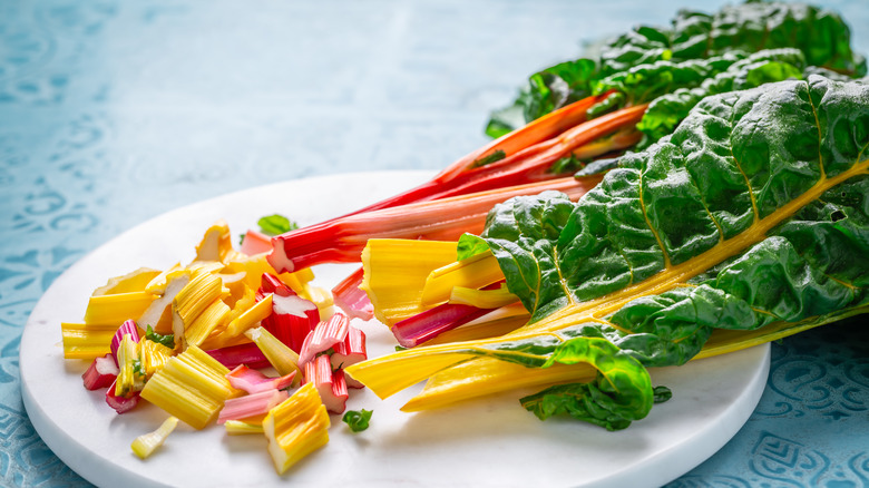 swiss chard cut up on a white platter on a blue counter