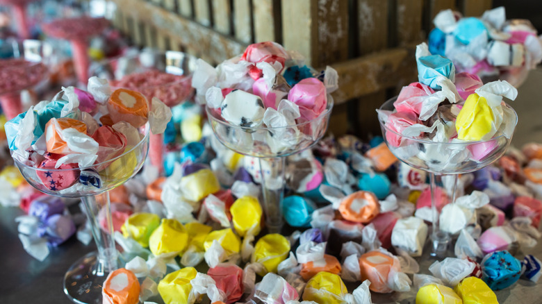 Salt water taffy in glass stemware with taffy scattered all around