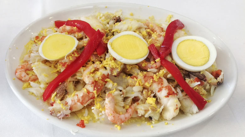 Mixed seafood on platter with boiled eggs and roasted red peppers