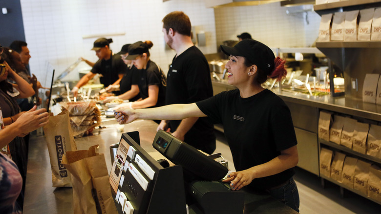 Chipotle cashier handing card to customer 