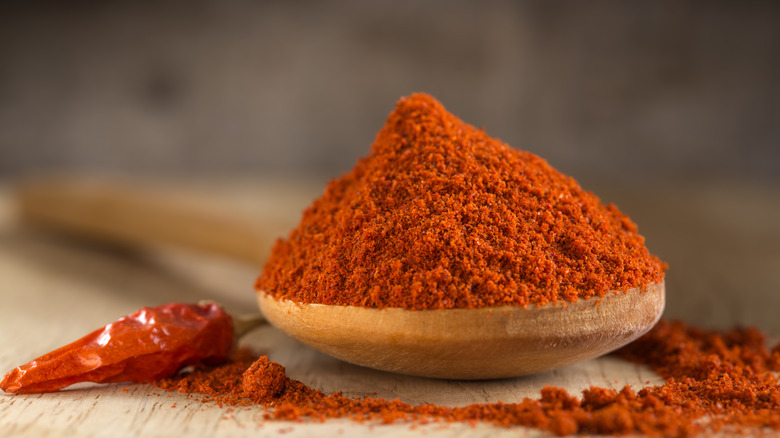 Wooden spoon of paprika with chili pepper