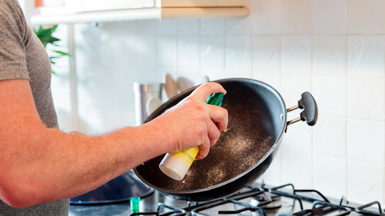 Man adding cooking spray