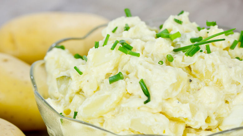 Creamy and thick potato salad in a bowl with chives