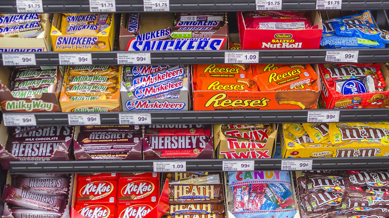 A shelf of assorted candy bars at a grocery store
