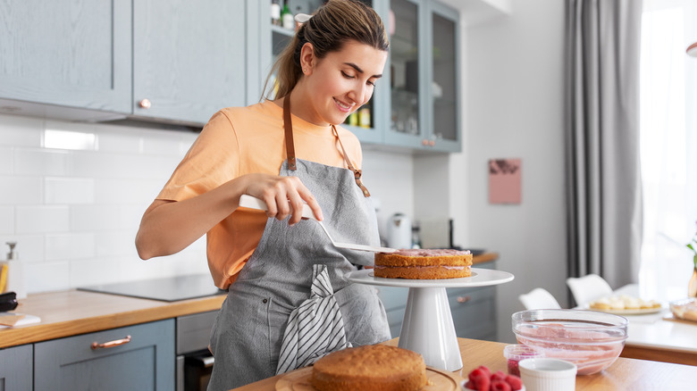 Woman frosting cake in kitchen 