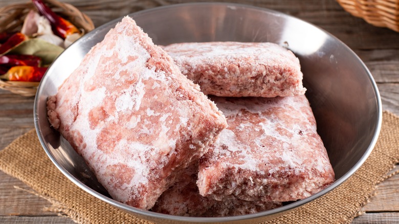 Frozen ground beef in a metal bowl 