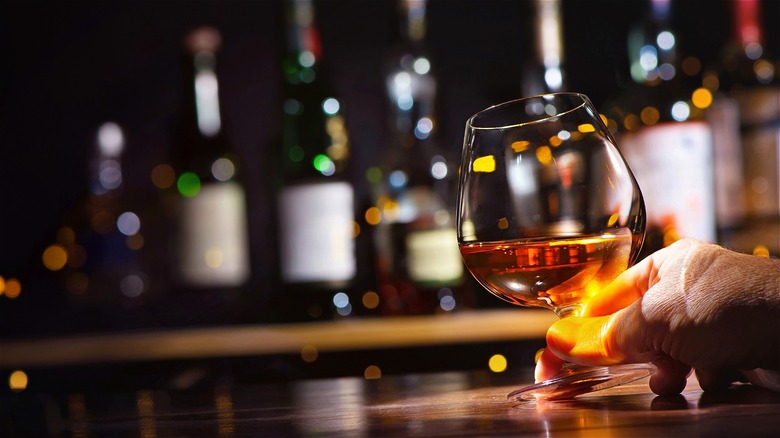 Hand holding whiskey glass