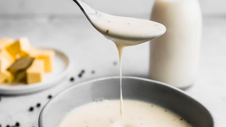 béchamel sauce in a spoon and bowl