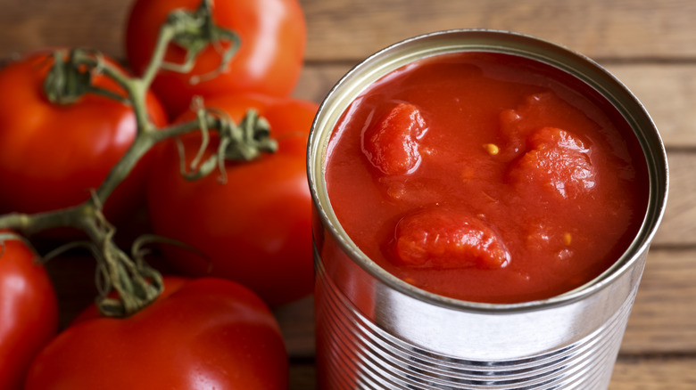 can of tomatoes with fresh vine tomatoes in background