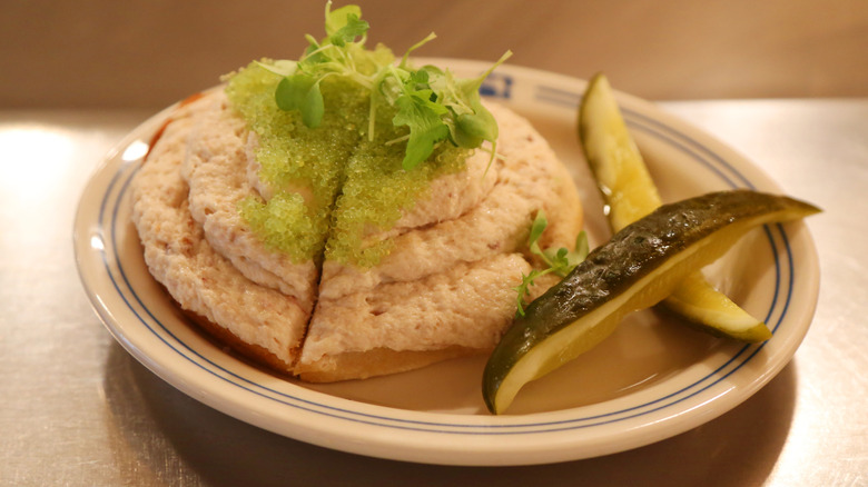 Whitefish salad on a bagel with a pickle
