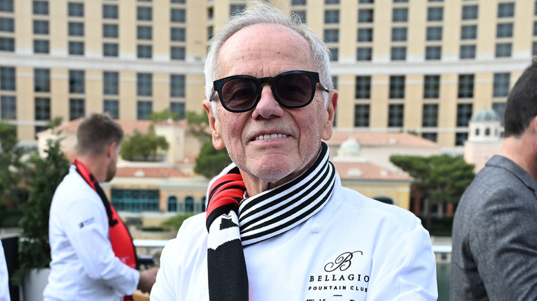 Wolfgang Puck at the Bellagio Fountain Club in a chef's jacket and Formula 1 scarf.