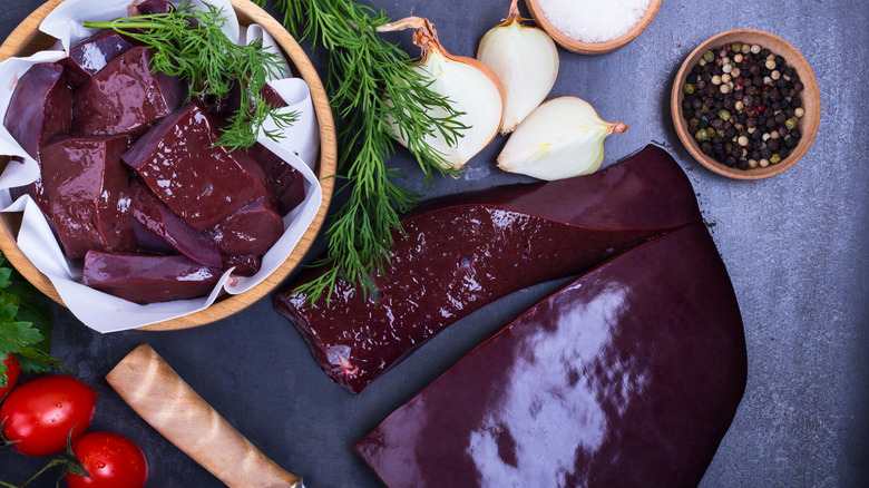 raw liver and raw onions on a cutting board