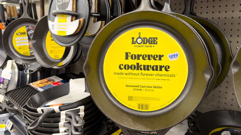 Lodge pans for sale in a store, with a yellow sticker that says "Forever cookware made without forever chemicals"