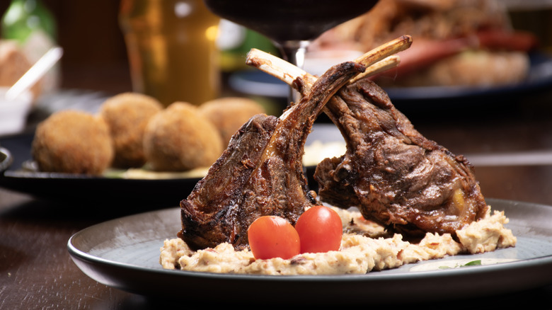 A high-end steak dinner with two pieces of t-bone steak on a plate at a steakhouse